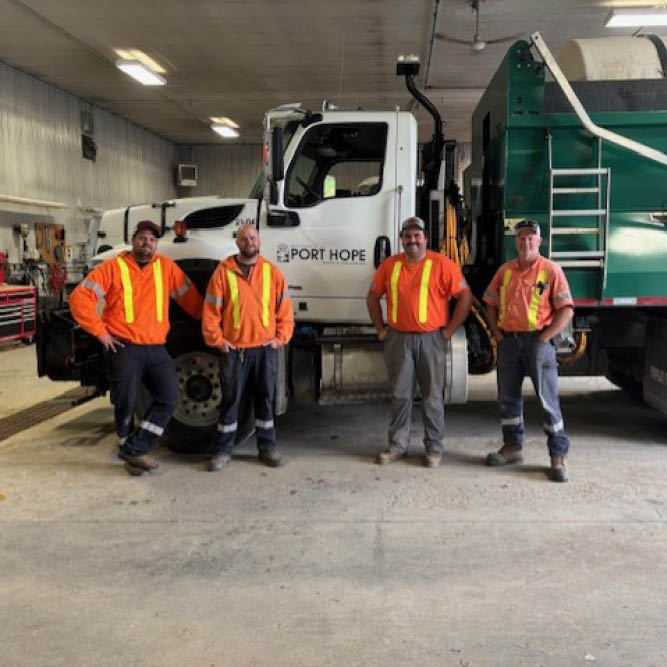 image of 4 workers in front of plow